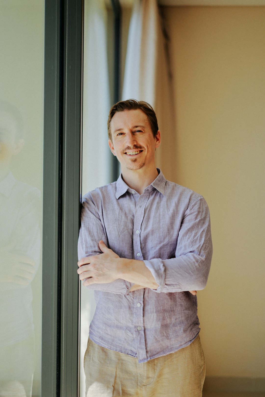 a smiling man leaning against a window lance crosby tech entrepreneur cloud computing