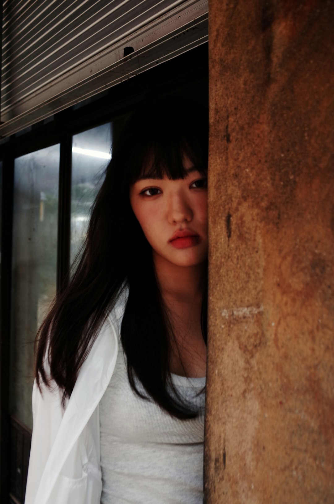 a woman is standing behind a wall and looking at the camera lee seo hwan acting dramatic scene emotional expression 1