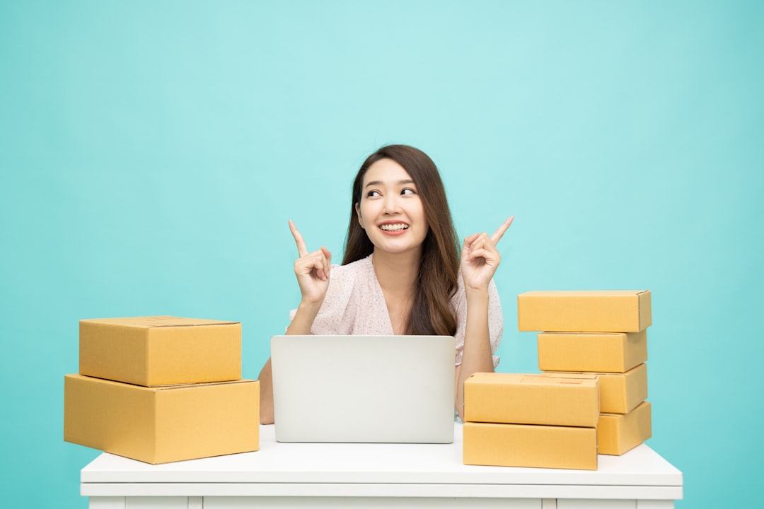 a woman sitting at a table with a laptop surrounded by boxes happy online shopping packages taobao delivery