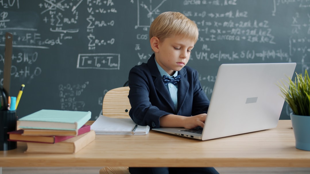 boy in suit using laptop in classroom education tech online learning ai tutor