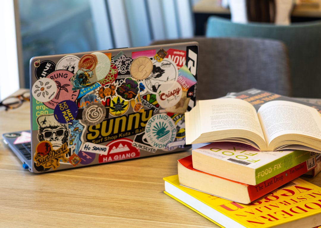 laptop and books sit on a wooden table html5 game school chromebook student gaming