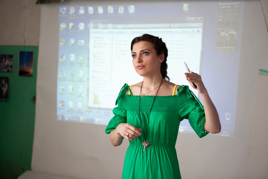 woman in green dress presenting with projector screen projection screen keynote presentation voiceover navigation teacher classroom