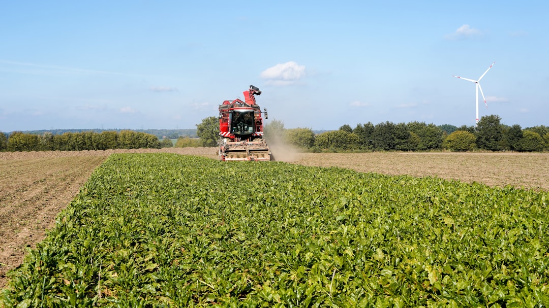 red combine harvester working in a field of green crops smart irrigation water conservation field automation 1