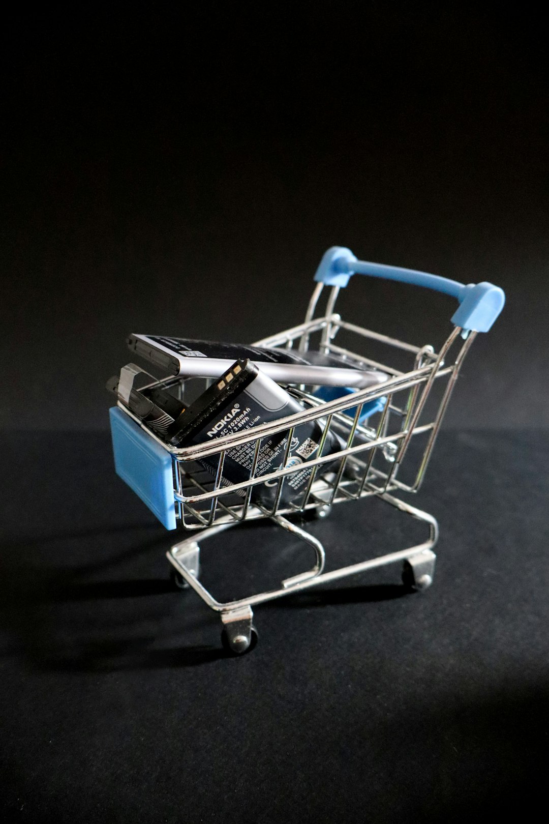 a miniature shopping cart with a cell phone in it side cart popup mobile ecommerce sidebar cart online shopping interface clean design