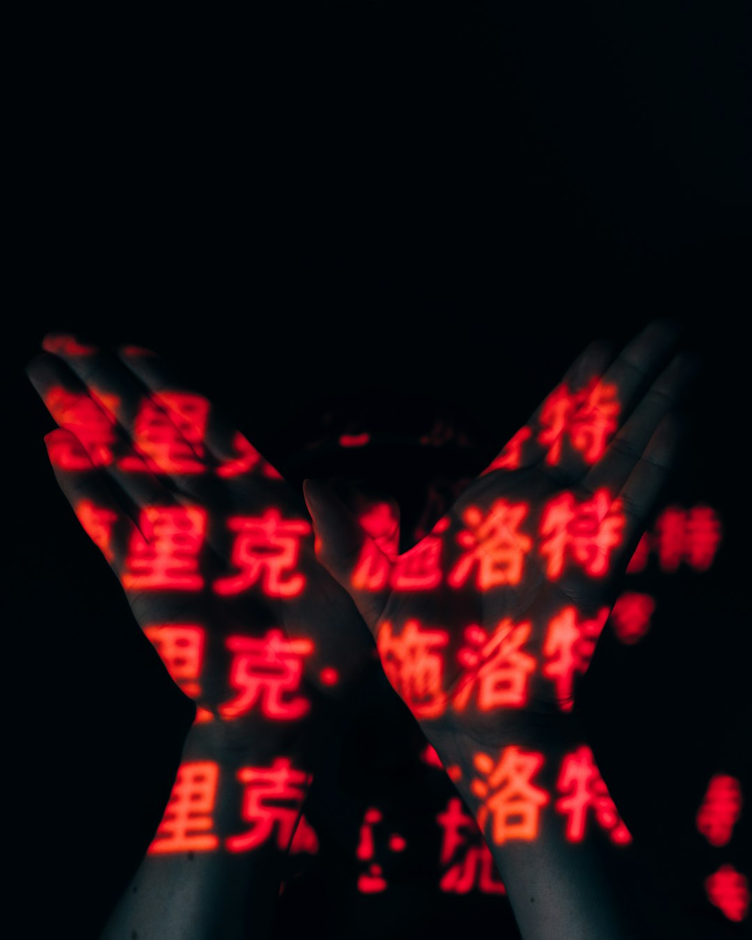 a person holding their hands up in the dark digital mystery glowing symbols dark background