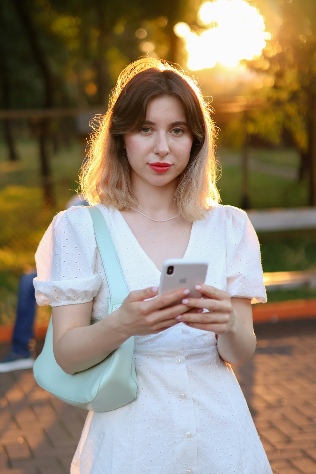 a woman in a white dress holding a cell phone person using smartphone settings privacy options screen headphones nearby