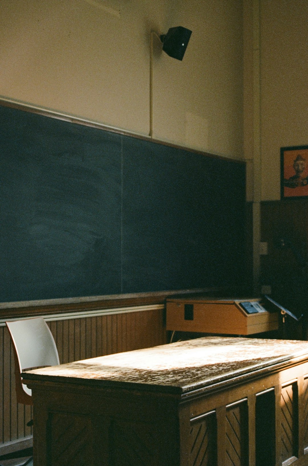 an empty classroom with a blackboard and desk teacher laptop grading automation classroom