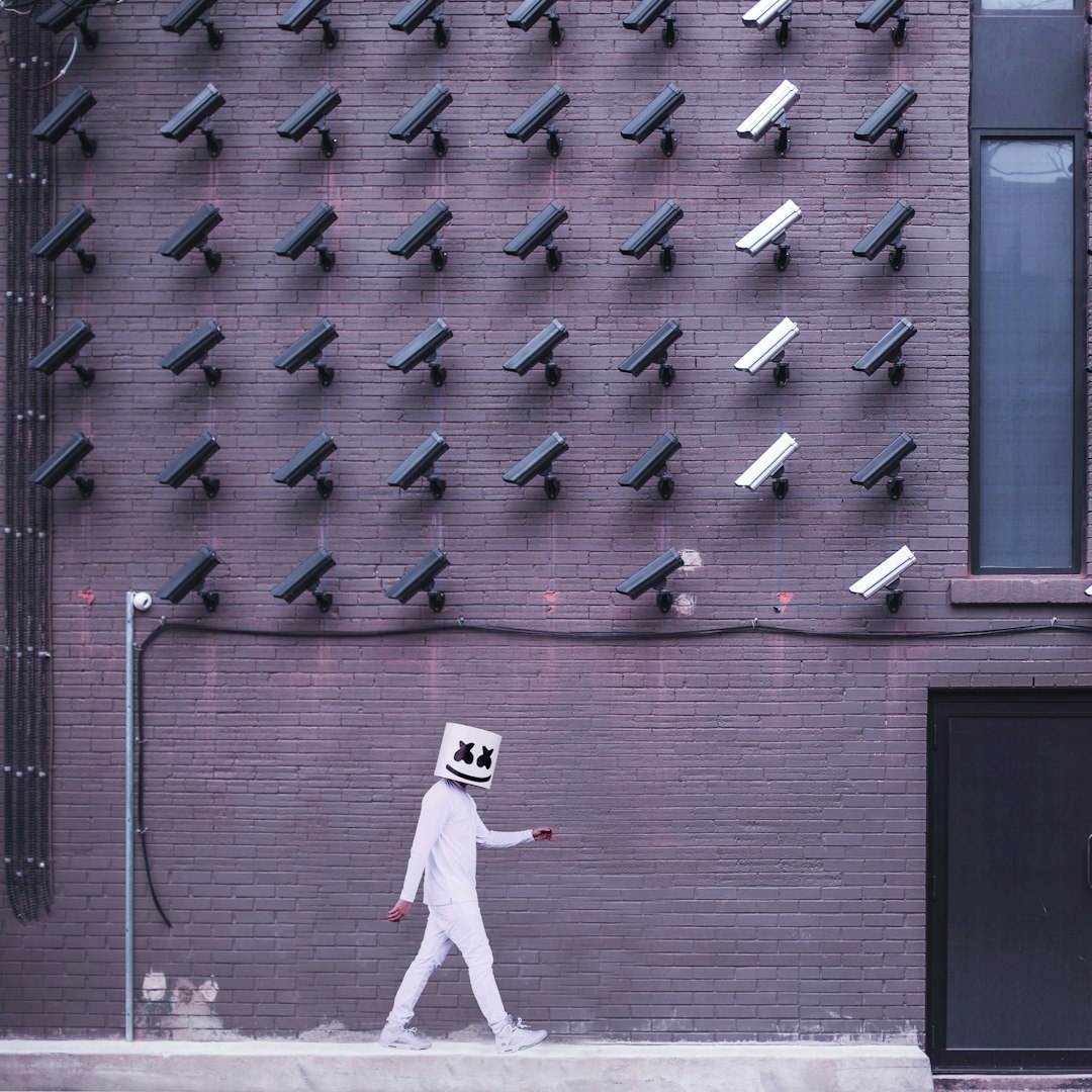 marshmello walking down the side of the road with camera on the top of the building data privacy concept secure information compliance symbols