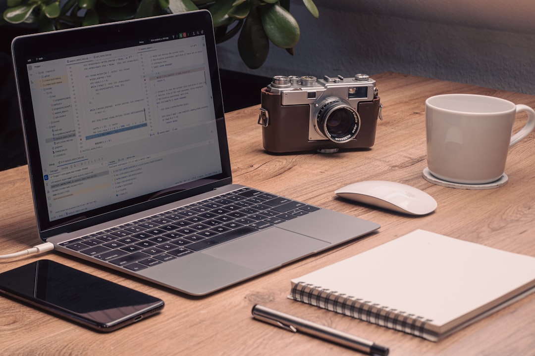 laptop phone camera and coffee mug on desk laptop showing vsco profile page browser address bar creative photography website