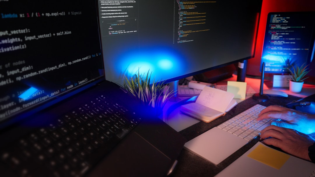 programmer coding at a desk with several monitors professional working on laptop in modern office privacy concept blurred screen