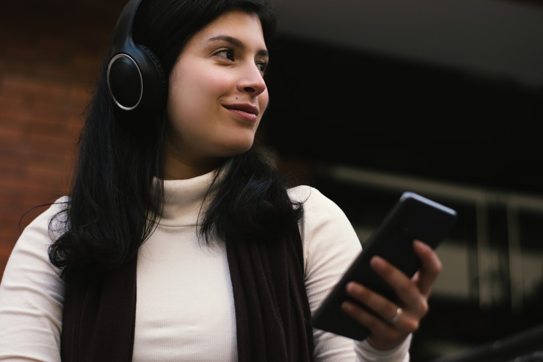 woman wearing headphones holds a smartphone customer support agent headset computer multilingual chat
