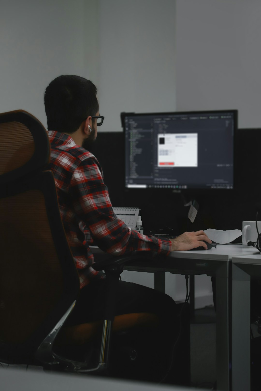 a man sitting at a desk with a computer collaborative editing screen structured content fields developer workspace real time updates